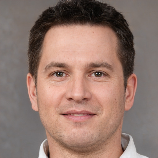 Joyful white adult male with short  brown hair and brown eyes