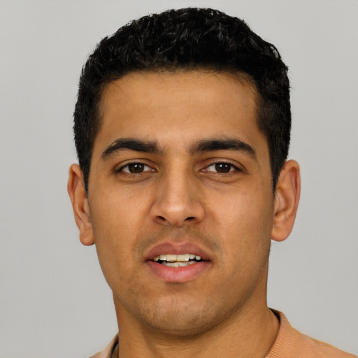 Joyful latino young-adult male with short  black hair and brown eyes