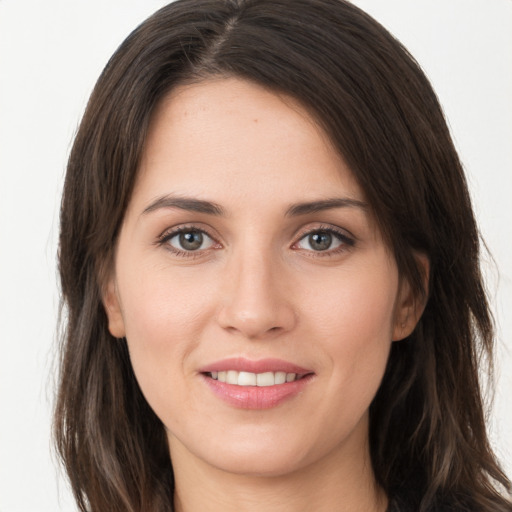 Joyful white young-adult female with long  brown hair and brown eyes