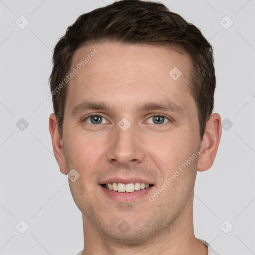 Joyful white young-adult male with short  brown hair and grey eyes