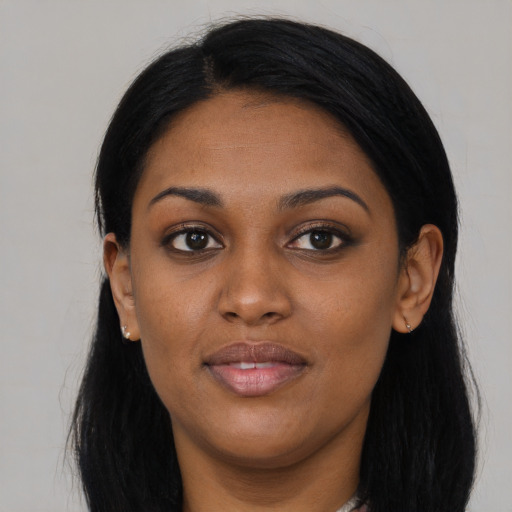 Joyful black young-adult female with long  black hair and brown eyes