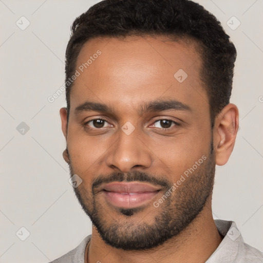 Joyful black young-adult male with short  black hair and brown eyes