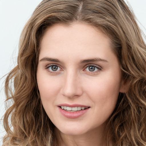 Joyful white young-adult female with long  brown hair and blue eyes