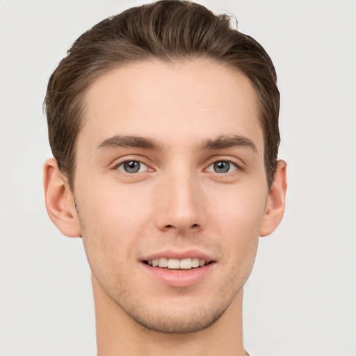 Joyful white young-adult male with short  brown hair and grey eyes