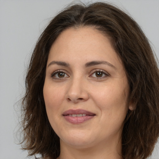Joyful white adult female with long  brown hair and brown eyes