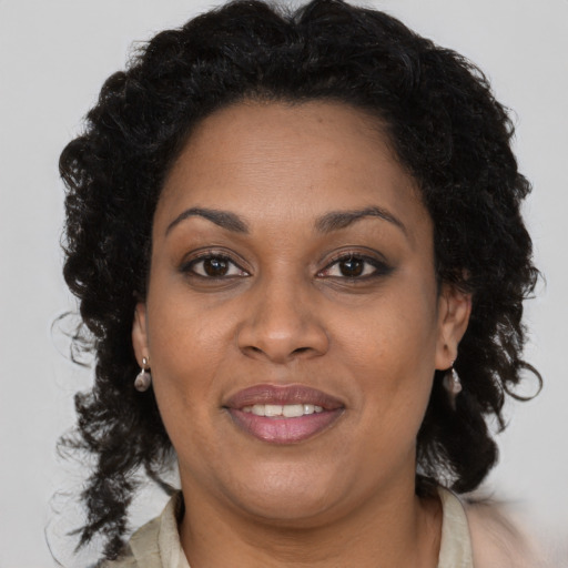 Joyful black adult female with long  brown hair and brown eyes