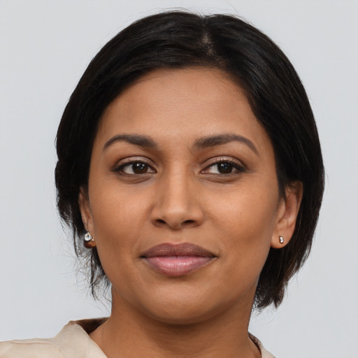 Joyful latino adult female with medium  brown hair and brown eyes