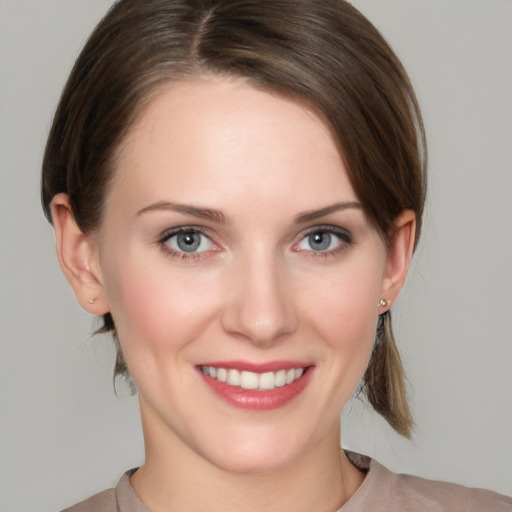 Joyful white young-adult female with medium  brown hair and grey eyes