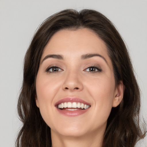 Joyful white young-adult female with long  brown hair and brown eyes