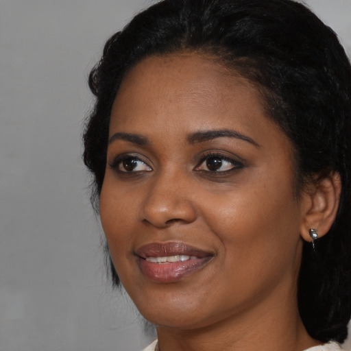 Joyful black young-adult female with medium  black hair and brown eyes