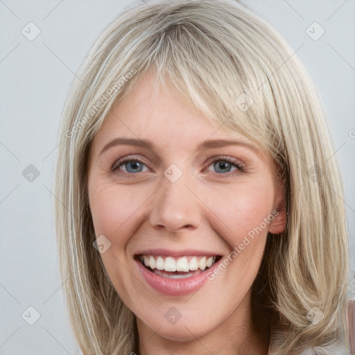 Joyful white young-adult female with long  brown hair and blue eyes