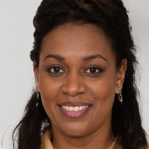 Joyful black adult female with long  brown hair and brown eyes