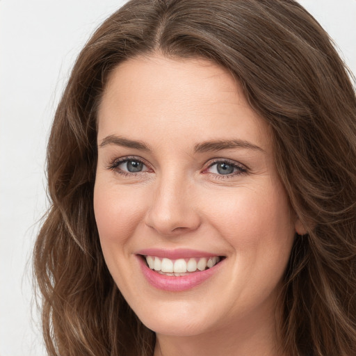 Joyful white young-adult female with long  brown hair and green eyes