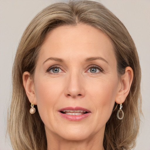 Joyful white adult female with medium  brown hair and grey eyes