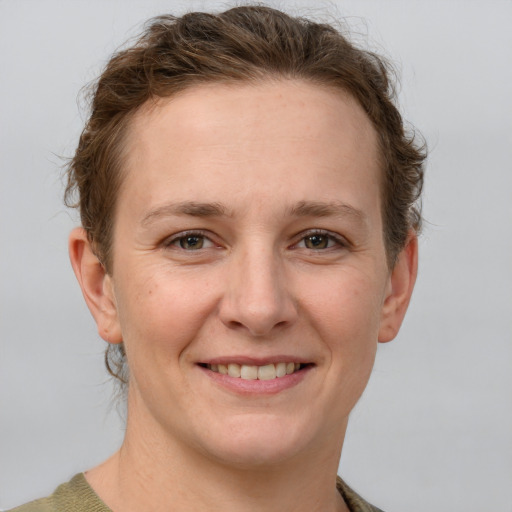 Joyful white young-adult female with short  brown hair and grey eyes