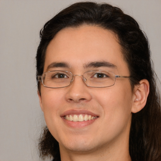 Joyful white young-adult male with long  brown hair and brown eyes