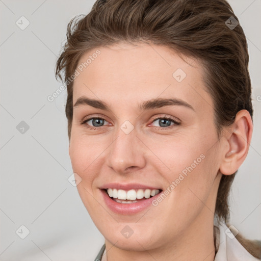 Joyful white young-adult female with short  brown hair and grey eyes