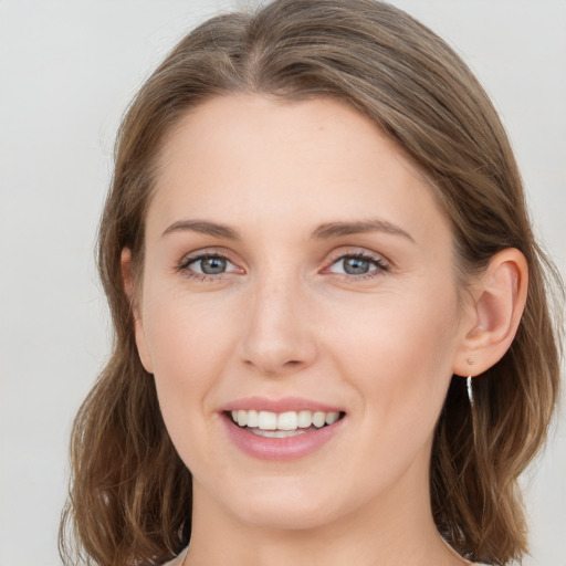 Joyful white young-adult female with medium  brown hair and grey eyes