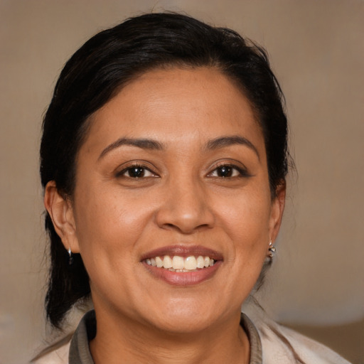 Joyful latino adult female with medium  brown hair and brown eyes