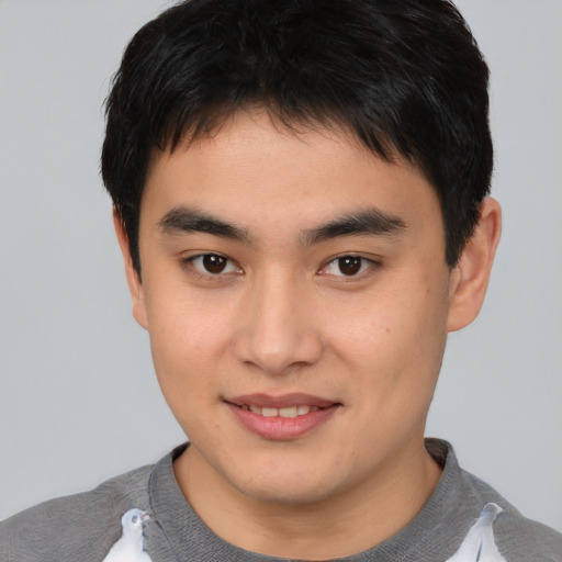 Joyful asian young-adult male with short  brown hair and brown eyes