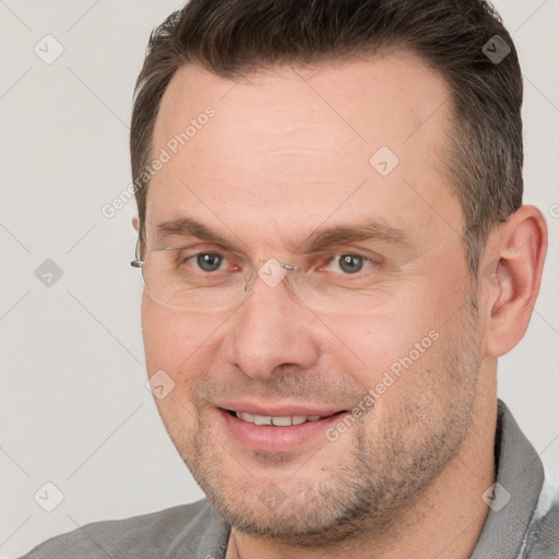 Joyful white adult male with short  brown hair and grey eyes