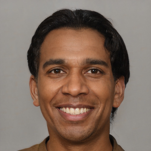 Joyful black young-adult male with short  black hair and brown eyes