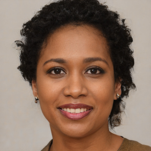 Joyful black young-adult female with short  brown hair and brown eyes