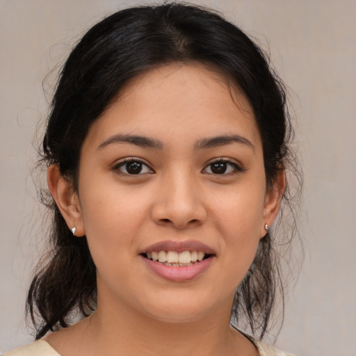 Joyful latino young-adult female with medium  brown hair and brown eyes