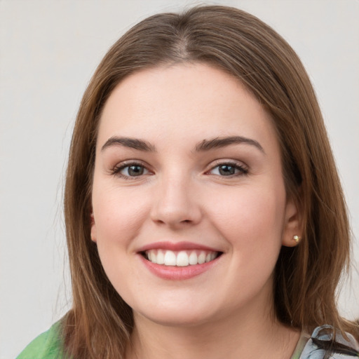 Joyful white young-adult female with medium  brown hair and green eyes