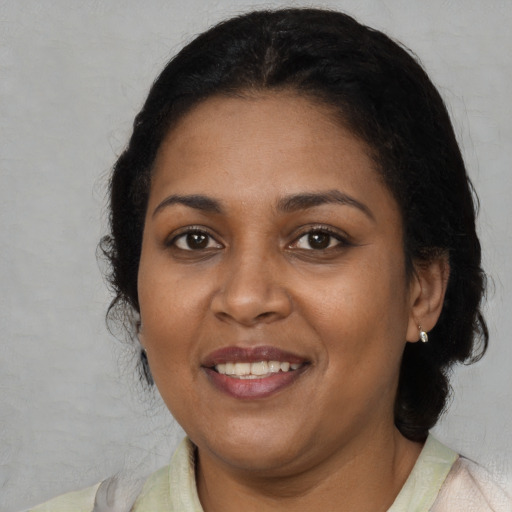 Joyful black adult female with medium  brown hair and brown eyes