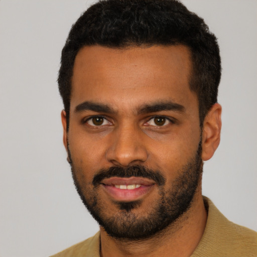 Joyful black young-adult male with short  black hair and brown eyes
