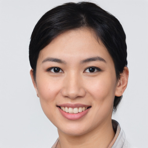 Joyful asian young-adult female with short  black hair and brown eyes