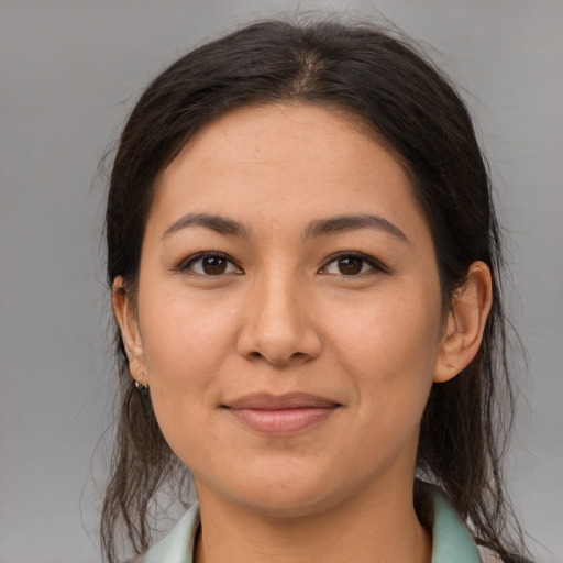 Joyful latino young-adult female with long  brown hair and brown eyes