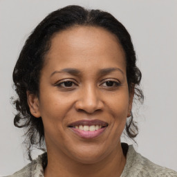 Joyful black adult female with medium  brown hair and brown eyes