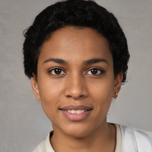 Joyful black young-adult female with short  black hair and brown eyes