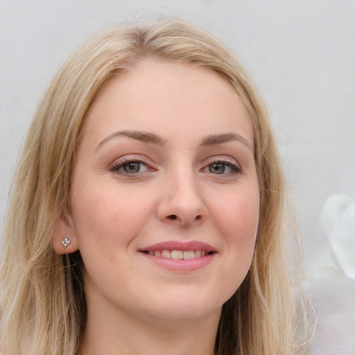 Joyful white young-adult female with long  brown hair and blue eyes