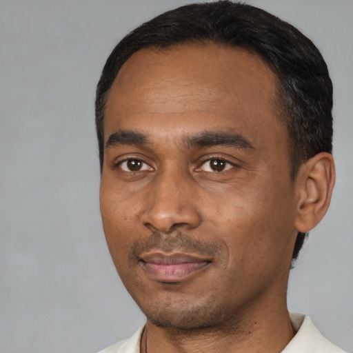 Joyful black young-adult male with short  black hair and brown eyes