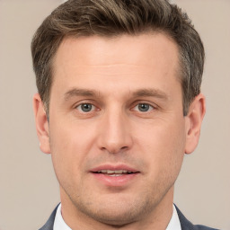 Joyful white young-adult male with short  brown hair and grey eyes