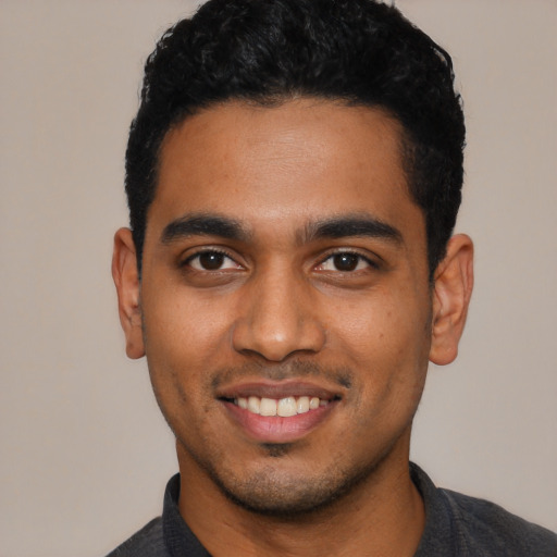 Joyful black young-adult male with short  black hair and brown eyes