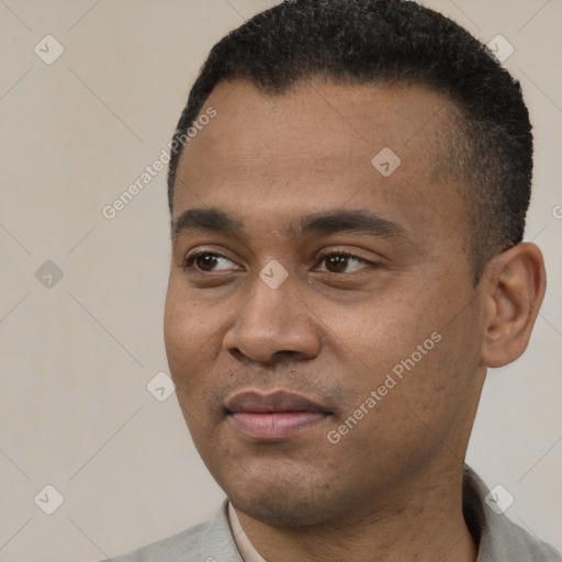 Joyful black young-adult male with short  black hair and brown eyes