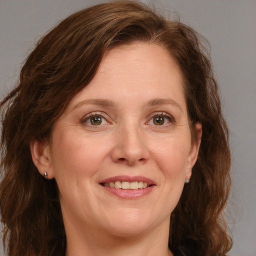 Joyful white adult female with long  brown hair and green eyes