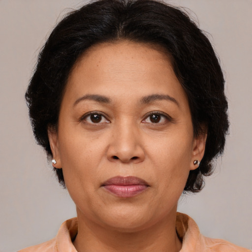Joyful latino adult female with medium  brown hair and brown eyes