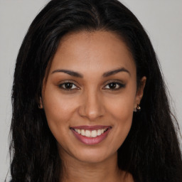 Joyful latino young-adult female with long  brown hair and brown eyes