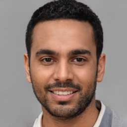 Joyful latino young-adult male with short  black hair and brown eyes