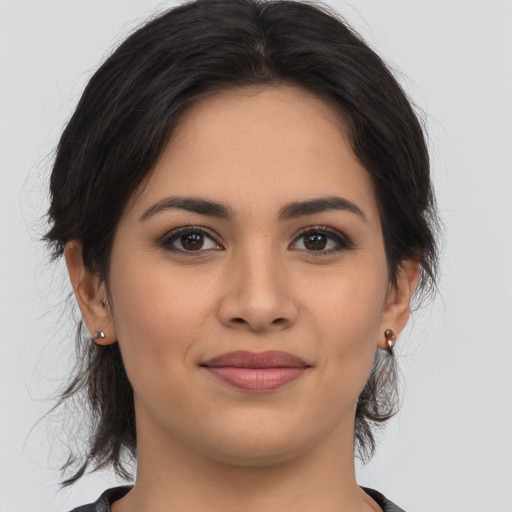 Joyful latino young-adult female with medium  brown hair and brown eyes