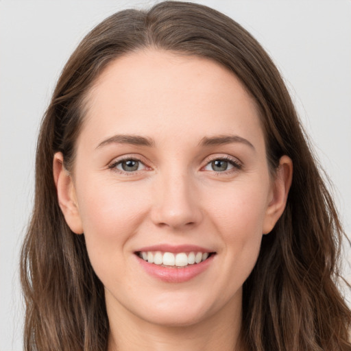 Joyful white young-adult female with long  brown hair and grey eyes