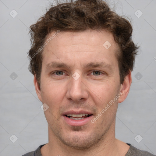 Joyful white adult male with short  brown hair and grey eyes