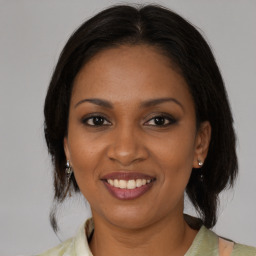 Joyful black young-adult female with medium  brown hair and brown eyes