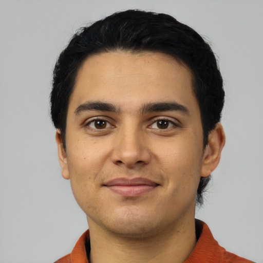 Joyful latino young-adult male with short  black hair and brown eyes