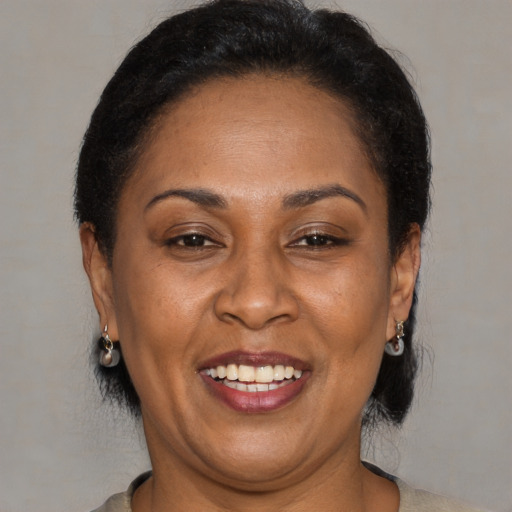 Joyful latino adult female with medium  brown hair and brown eyes